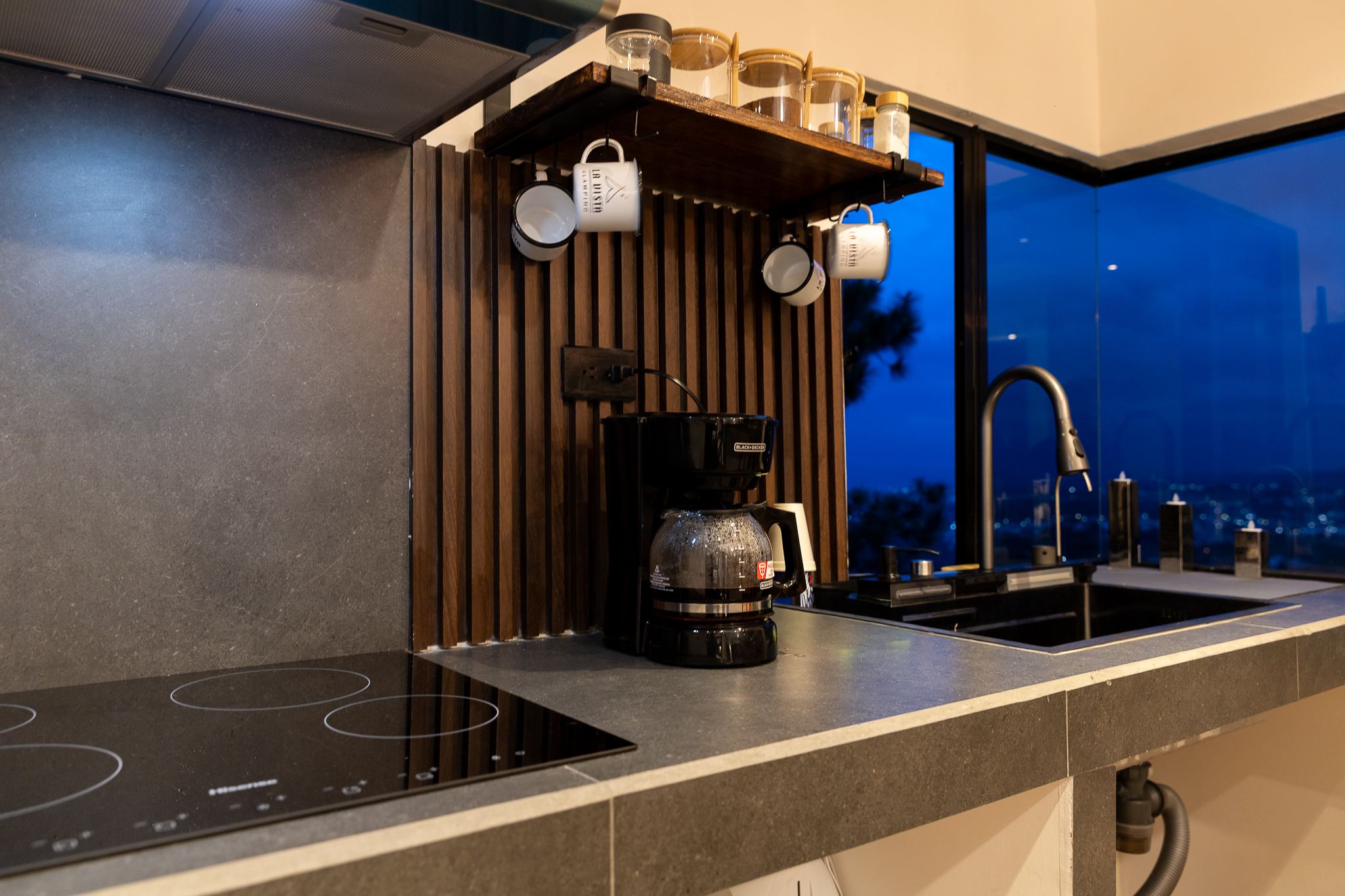 Cocina equipada con estufa, cafetera y ventana esquinera