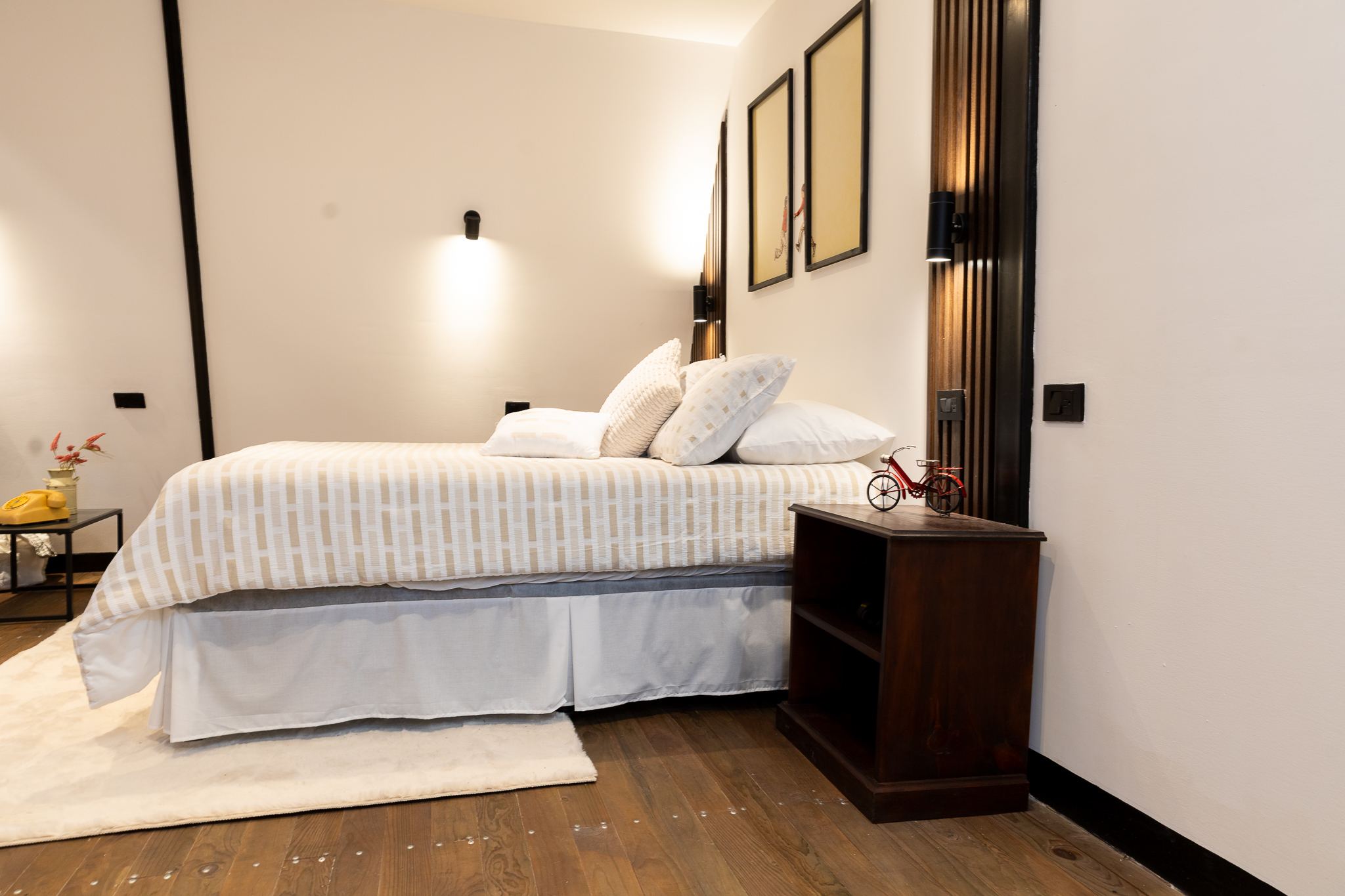 Habitación principal con cama queen, luz cálida y piso de madera