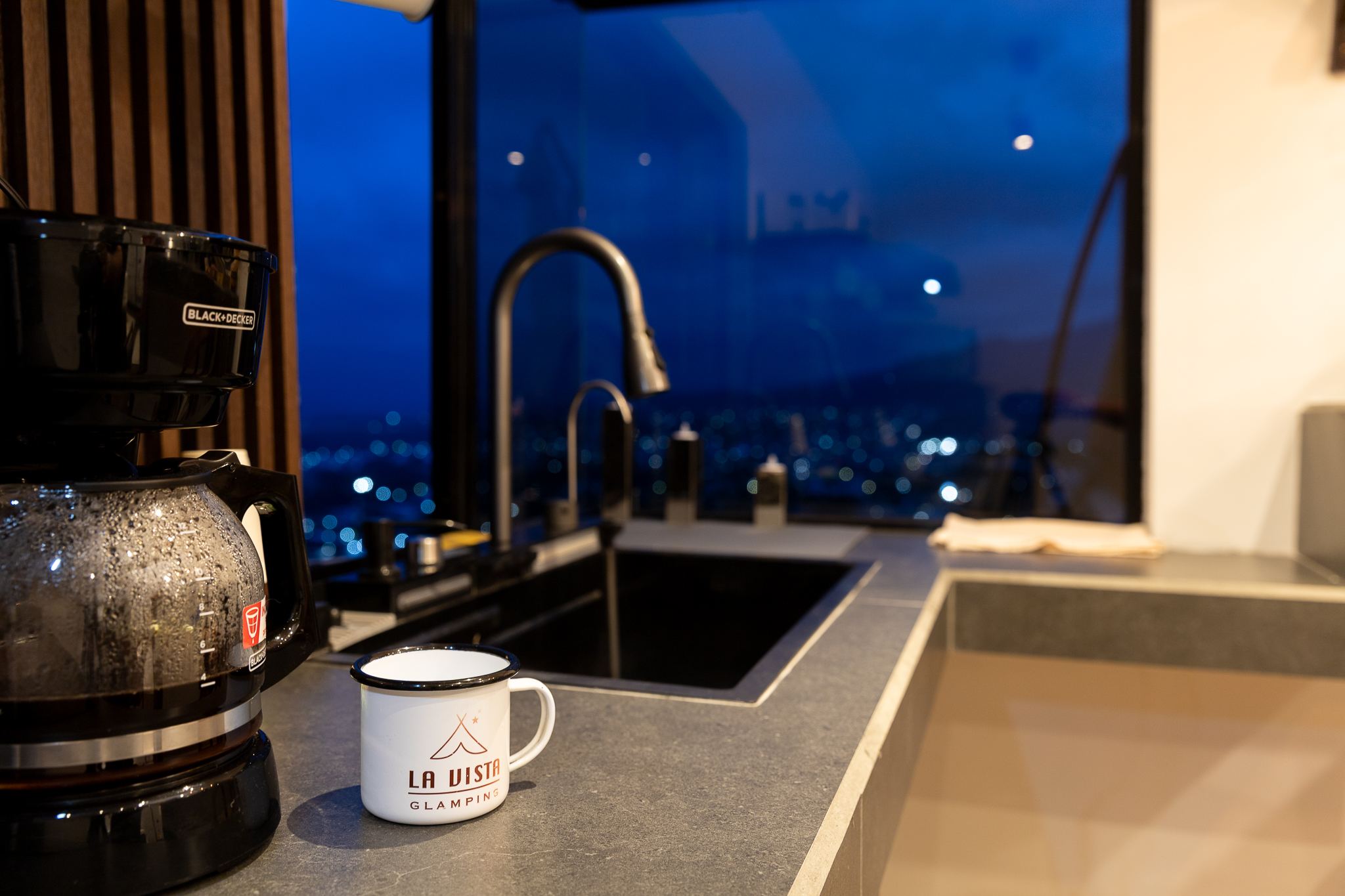 Taza con el logo de La Vista junto a la ventana de la cocina